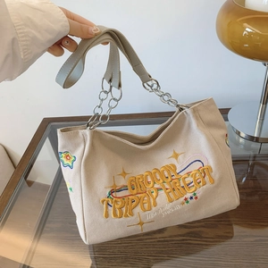 Chic beige canvas tote bag with colorful embroidery and chain strap for daily commute