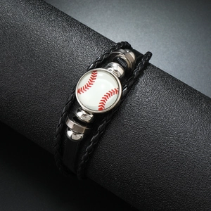 Détail d'un bracelet en cuir tressé noir avec un pendentif baseball et billes argent