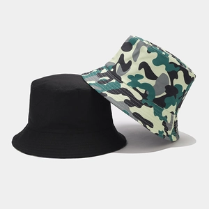 Detail of reversible camouflage and solid black cotton canvas bucket hats for sun protection