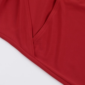 Detail view of red fabric showing fine double-stitch sewing and high-quality textile texture