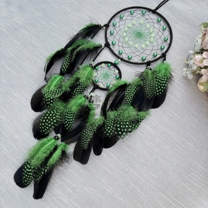 Handmade luminous dream catcher with black rings and green feathers for wall hanging decor