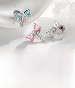 Detail of ribbon bow stud earrings with heart zirconia in blue, pink and white