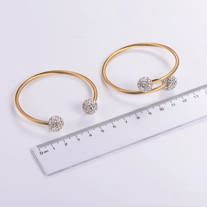 Top view of adjustable twisted wire bangle with diamond spheres and a ruler for size reference