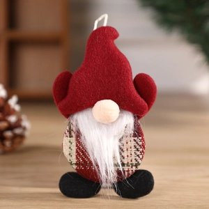 Christmas gnome hanging ornament with red hat and white beard on a cozy wooden background