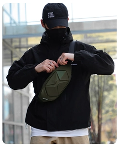 Detail of army green hardshell crossbody bag with geometric 3D design on outdoor model