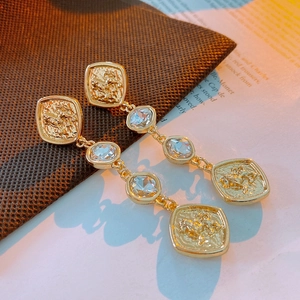 Detailed view of vintage lion head tassel earrings with crystals and gold finish
