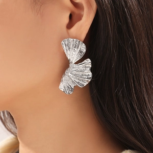 Chic silver ginkgo leaf earrings with hammered texture on elegant female model