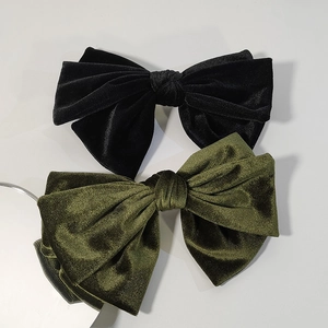 Detail of premium velvet bow hair clips in black and dark green with spring mechanism