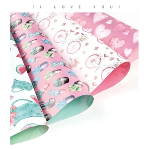 Detail view of four gift wrapping paper rolls with pink cactus and heart patterns