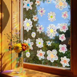 Floral rainbow suncatcher stickers on a window glass creating colorful prism light effects