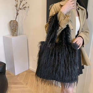 Large black plush tote bag with fluffy faux fur styled on a model in a trench coat