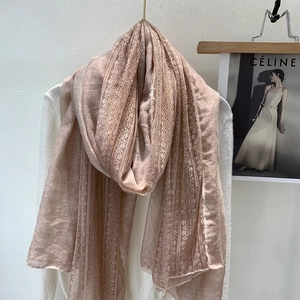 Close-up of pink linen scarf featuring delicate lace stitching and striped texture