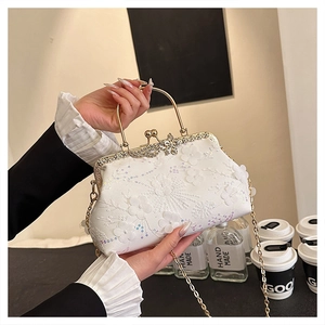 Detail of pearl white evening bag with floral embroidery and sparkling sequins