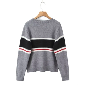 Détail du cardigan en maille grise avec rayures horizontales blanches, noires et rouges