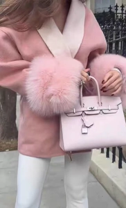 Dettaglio cappotto di lana rosa con polsini in pelliccia e borsa rosa coordinata