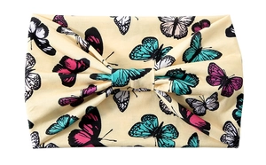 Close-up of wide stretch headband featuring colorful butterfly patterns on beige fabric