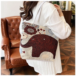 Detail of ethnic style beige canvas tote bag with red elephant and floral prints