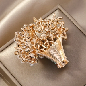 Detailed back view of vintage gold flower basket brooch with metal pin and faux pearls