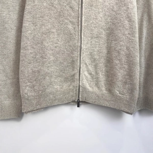 Front view of a light gray knit zip-up hoodie featuring a soft texture and ribbed hem