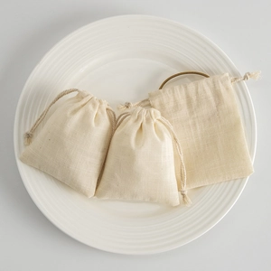 Close-up of cotton linen drawstring pouch showing fabric texture on white ceramic plate