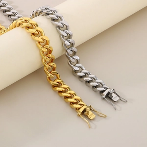 18K gold and silver 13mm Cuban link bracelets set on a minimalist pedestal