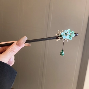 Detail of vintage flower hair pin with blue petals and green marbled bead tassel