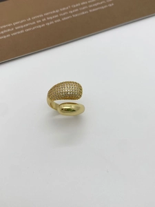 Close-up of golden teardrop bangle with shimmering cubic zirconia stones on white background