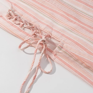 Detail of pink and white striped dress with side tie-up bow and woven cotton texture