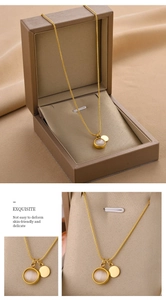 Détail du collier chaîne serpent dorée avec pendentif opale sur soie beige