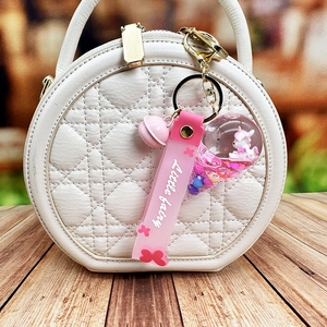 Pink floating unicorn keychain with Little Fairy strap on a luxury white quilted bag