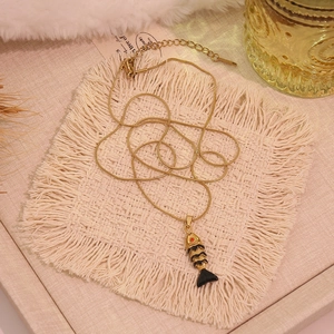 Gros plan d'un collier chaîne serpent dorée avec un pendentif carpe koi noir et or