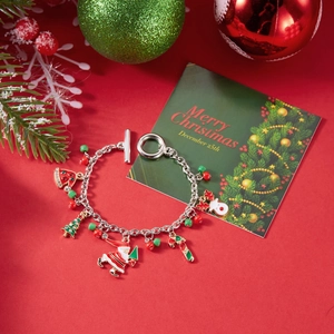 Christmas charm bracelet featuring Santa, reindeer and tree charms on a red festive background