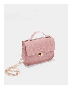Macro detail of pink crocodile pattern texture and gold chain on the square bag