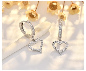 Detailed close-up of luxury heart earrings with sparkling cubic zirconia on a warm background