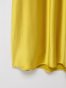 Gros plan détaillé sur la texture du satin jaune et la finition soignée de l'ourlet