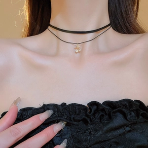 Close-up of double-layer black choker necklace featuring a sparkling zircon cherry pendant