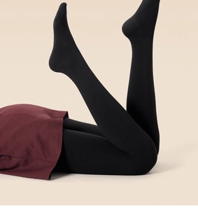 Detail of thick black ribbed thermal leggings showing elastic knit texture and slim fit