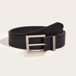 Macro shot of black leather belt with silver square buckle and stitched edges on beige background