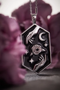 Nahaufnahme der sechseckigen Tarot-Halskette mit schwarzer Emaille-Rose und Sternen