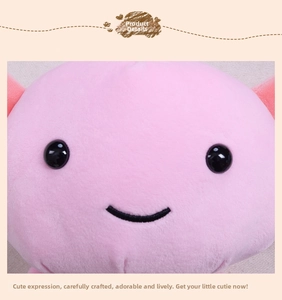 Close-up of pink axolotl plush showing black bead eyes and embroidered smiley face