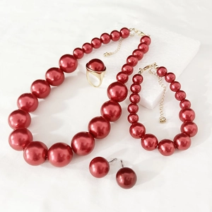 Elegant red faux pearl jewelry set with necklace, bracelet, ring and earrings on white background