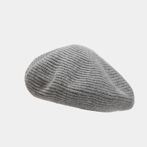 Detailed macro view of the grey wool knit texture on a cozy winter beret hat