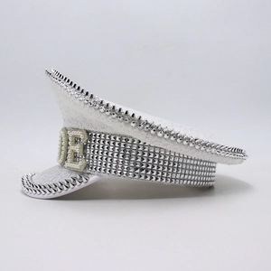 Close-up of white sequin party hat with silver rivets and pearl letter decorations