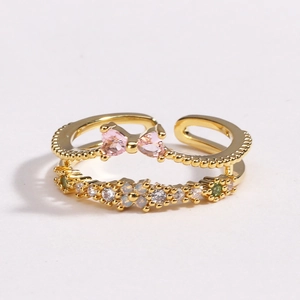 Détail d'une bague double couche dorée avec papillon en zircon rose et cristaux