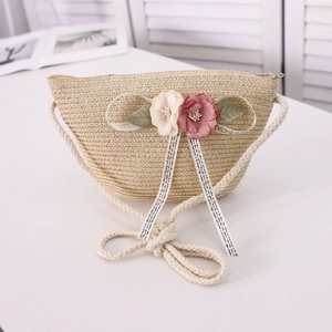 Close-up of woven straw bag with handmade fabric flowers and chic ribbon detail