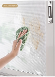 Close-up of flexible green silicone brush cleaning window screen mesh with foam