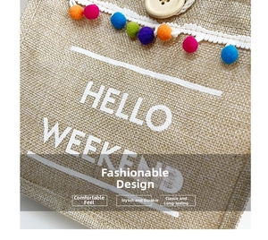 Detail of jute tote bag with lace trim, colorful pom poms, and HELLO WEEKEND text
