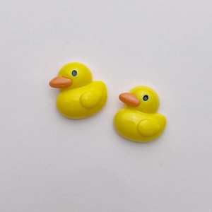 Detailed view of two glossy yellow resin duck charms for DIY crafts and hair accessories