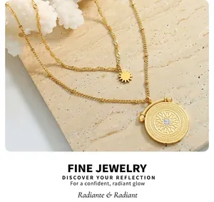 Detail of gold double-layer necklace with sun pendant and stone-set engraved medallion