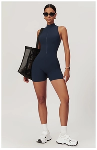 Close-up of navy blue high-stretch yoga romper featuring a stand collar and front zipper
